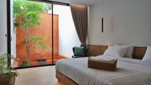 a bedroom with a bed and a large glass window at Tree Space Living in Ban Don Ta Koet