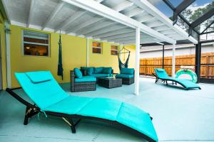 a patio with a couch and chairs and a swing at Family friendly paradise Pool Home! in Palm Bay