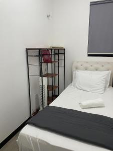 a bedroom with a white bed and a book shelf at HARRAZ SUITE PUTRAJAYA just minutes away from PICC and KPT perfect for both business and leisure stays in Putrajaya +39 photos