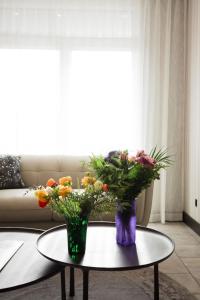 two vases with flowers on a table in a living room at the reid hotel in Vanderhoof