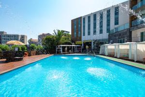 a large blue swimming pool in front of a building at Amoureux Resort in Jeju