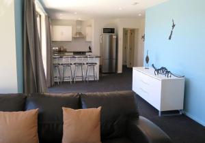 ein Wohnzimmer mit Sofa und eine Küche in der Unterkunft Alpine Nook in Lake Tekapo