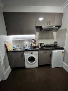 a kitchen with a washing machine and a sink at Penzance Cottage Glenelg in Glenelg