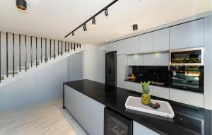 a kitchen with white cabinets and a black counter top at Villa Eclips in Zaton