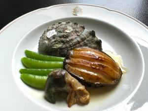 a plate of food with meat and vegetables on it at Ofunato Onsen in Ōfunato