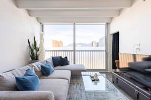 バンクーバーにあるCozy 1BR with AC, Chinatown, Rogers Arena, Seawallのソファと大きな窓のあるリビングルーム