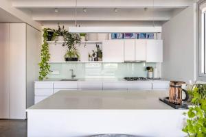 バンクーバーにあるCozy 1BR with AC, Chinatown, Rogers Arena, Seawallの白いキャビネットと大きな島のあるキッチン