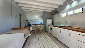 a kitchen with a bed and a table in a room at Entre Las Sierras Tiny House Cabañas in Villa Giardino