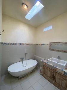a bathroom with a bath tub and a sink at Mango 5 Hotel in Amed