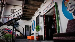 un edificio bianco con scale e porta nera di Terra House Hostel a Cuzco