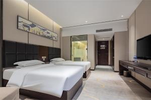 A bed or beds in a room at 宜昌虹桥国际大酒店