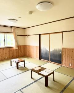 a room with two tables and a large window at Tengudaira Mountain Lodge in Tateyama