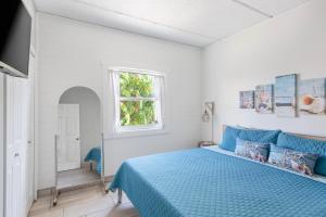 a bedroom with a blue bed and a window at SPI Beach Condo - Just a block away to Paradise in South Padre Island