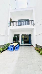 un patio avec une table et deux bancs bleus dans l'établissement 1988 Homestay Vũng Tàu, à Vung Tau