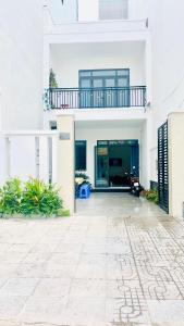 une maison blanche avec un balcon et une cour dans l'établissement 1988 Homestay Vũng Tàu, à Vung Tau