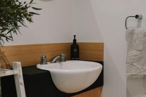 a white sink in a bathroom with a bottle of wine at Cosy Cottage in Geraldton - "Moresby Rest" in Bluff Point +55 photos