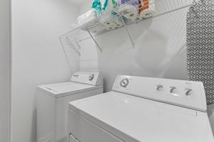 a white laundry room with a washing machine and a drying rack at Chic 1BR Oasis Ideal Retreat near Six Flags in Austell