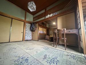 Ein Zimmer mit einem Tisch und einem Stuhl auf einem Teppich in der Unterkunft Azukiya in Hanabuchihama