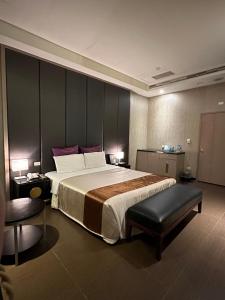 una camera d'albergo con un letto grande e una sedia di Purple Rainbow Motel a Taipei