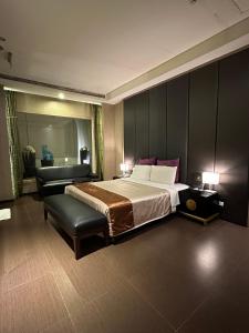 una stanza d'albergo con un letto e una sedia di Purple Rainbow Motel a Taipei