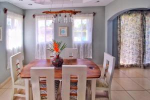 a dining room with a wooden table and white chairs at Casa Brisa, Gran Pacifica in Managua