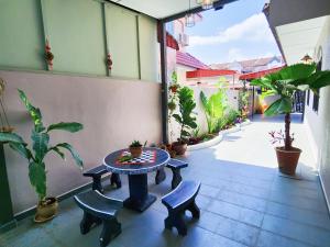 a patio with a table and two chairs and plants at IPOH Rainbow Blissful Villa, Persiaran Halaman Ampang Ipoh in Ipoh