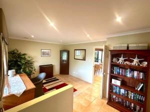 a living room with a book shelf filled with books at Anne's Retreat - Busselton in Busselton