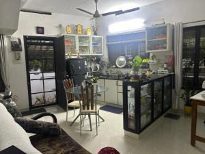 a kitchen with a glass table in a room at Chaithritha Ladies Homestay in Trivandrum +45 photos