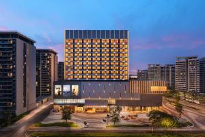 a large building in a city with tall buildings at Citadines Yazhou Bay Sanya in Sanya
