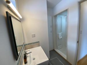 a white bathroom with a sink and a mirror at Yuki Kawa in Niseko +8 photos