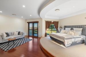 a bedroom with a large bed and a couch at Luxury Range Stay! 6 Bedroom 4 Bathroom in Thornlands +22 photos