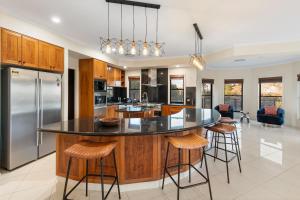 an open kitchen with a large island with bar stools at Luxury Range Stay! 6 Bedroom 4 Bathroom in Thornlands
