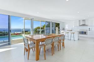 サンライズ・ビーチにあるSpectacular Beachside Living, Sunrise Beachのテーブルと椅子のあるキッチンとダイニングルーム