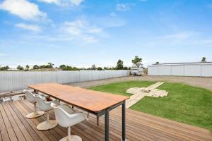 a wooden deck with a wooden table and chairs at The White House in Wellington East