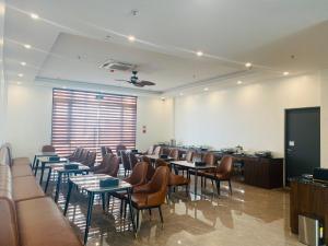 a conference room with tables and chairs and a screen at ATOUR Phoenix Hotel in Bắc Ninh