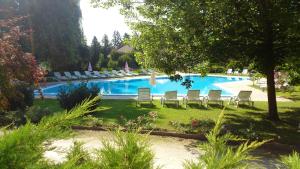 a swimming pool with lounge chairs in a yard at Batthyány Kastélyszálló in Zalacsány