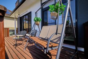 a swing on a porch with two potted plants at AOKI 富士河口湖眺望 BBQ送迎ok 貸切大型別荘 in Fujikawaguchiko