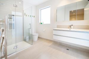 a white bathroom with a sink and a shower at Private Family City Retreat, Sleeps 8 in Christchurch +48 photos
