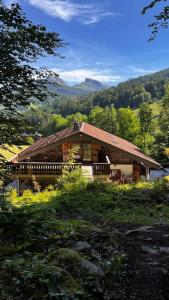 une cabane en rondins au milieu d'un champ dans l'établissement Magnifique ferme ancienne datant de 1877, à Saint-Jean-de-Sixt