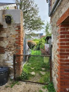 an iron gate in the side of a brick building at La maison du lavoir in Ballan-Miré