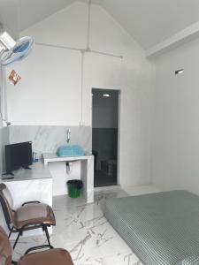 a bedroom with a bed and a desk and a chair at Minamo Homestay Modern Tengah Kota Payakumbuh in Payakumbuh