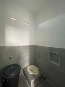 a bathroom with a toilet and a trash can at Minamo Homestay Modern Tengah Kota Payakumbuh in Payakumbuh