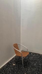 a chair sitting in the corner of a room at Minamo Homestay Modern Tengah Kota Payakumbuh in Payakumbuh