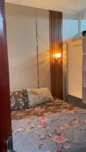 a bed in a room with a bedspread on it at Minamo Homestay Modern Tengah Kota Payakumbuh in Payakumbuh