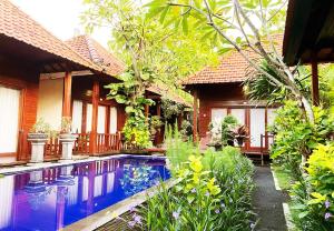 a house with a swimming pool in front of a house at Wait Garden Cottage in Nusa Penida
