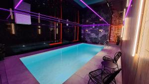 a swimming pool with purple lighting in a building at Villa Verona in Łeba