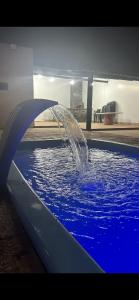 a fountain in a pool of blue water at Clube Araguaia in Caseara