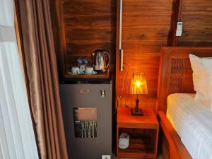a small room with a bed and a small refrigerator at Aming Villa Balangan in Jimbaran +2 photos