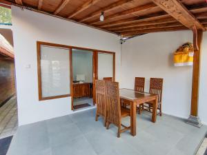 a dining room with a wooden table and chairs at Aming Villa Balangan in Jimbaran