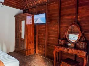 a bedroom with a mirror and a wooden wall at Aming Villa Balangan in Jimbaran
